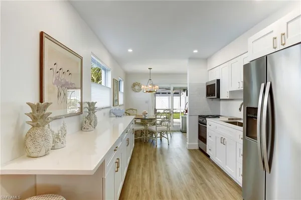 a kitchen with stainless steel appliances granite countertop a refrigerator a stove and a wooden floors