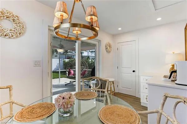 a dining room with wooden floor a glass table and chairs