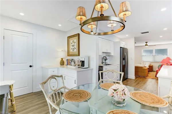 a view of a dining room with furniture a kitchen and wooden floor