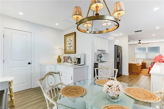a view of a dining room with furniture a kitchen and wooden floor