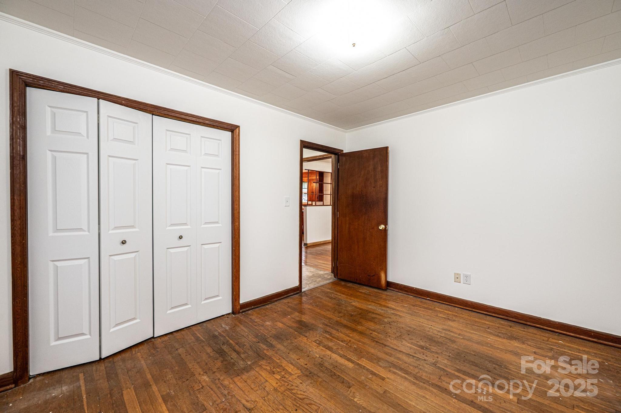 1214 Dry Ponds Road Granite Falls, NC 28630 - Photo 14 of 39 an empty room with wooden floor & closet area