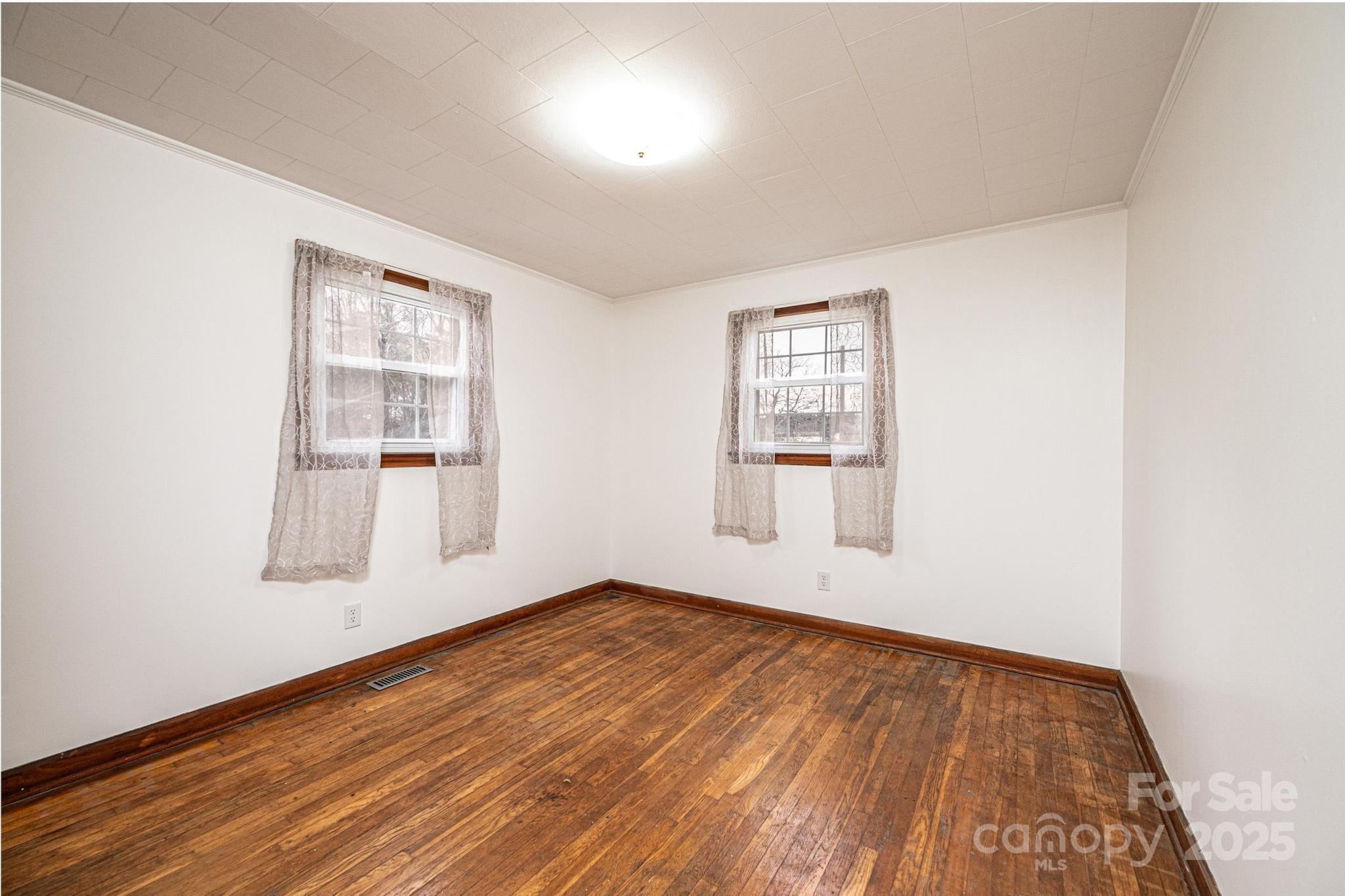 1214 Dry Ponds Road Granite Falls, NC 28630 - Photo 15 of 39 an empty room with wooden floor and windows