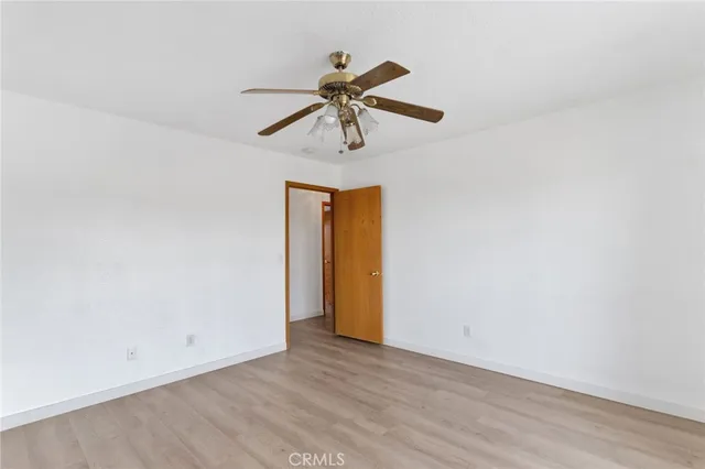 a view of a room with wooden floor and ceiling fan