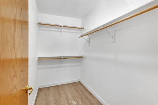 a view of walk in closet with empty racks