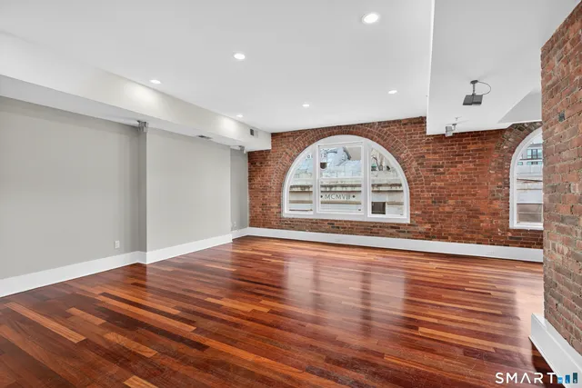 a view of empty room with wooden floor