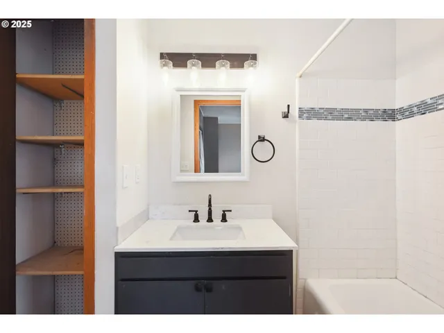 a bathroom with a sink vanity and a mirror