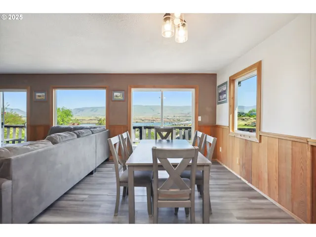 a dining room with furniture a chandelier and wooden floor
