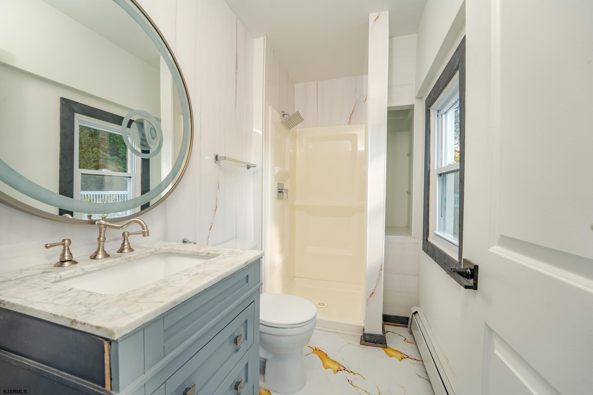 1203 West Mill Road Northfield, NJ 08225 - Photo 16 of 90 a bathroom with a granite countertop sink toilet a mirror and shower