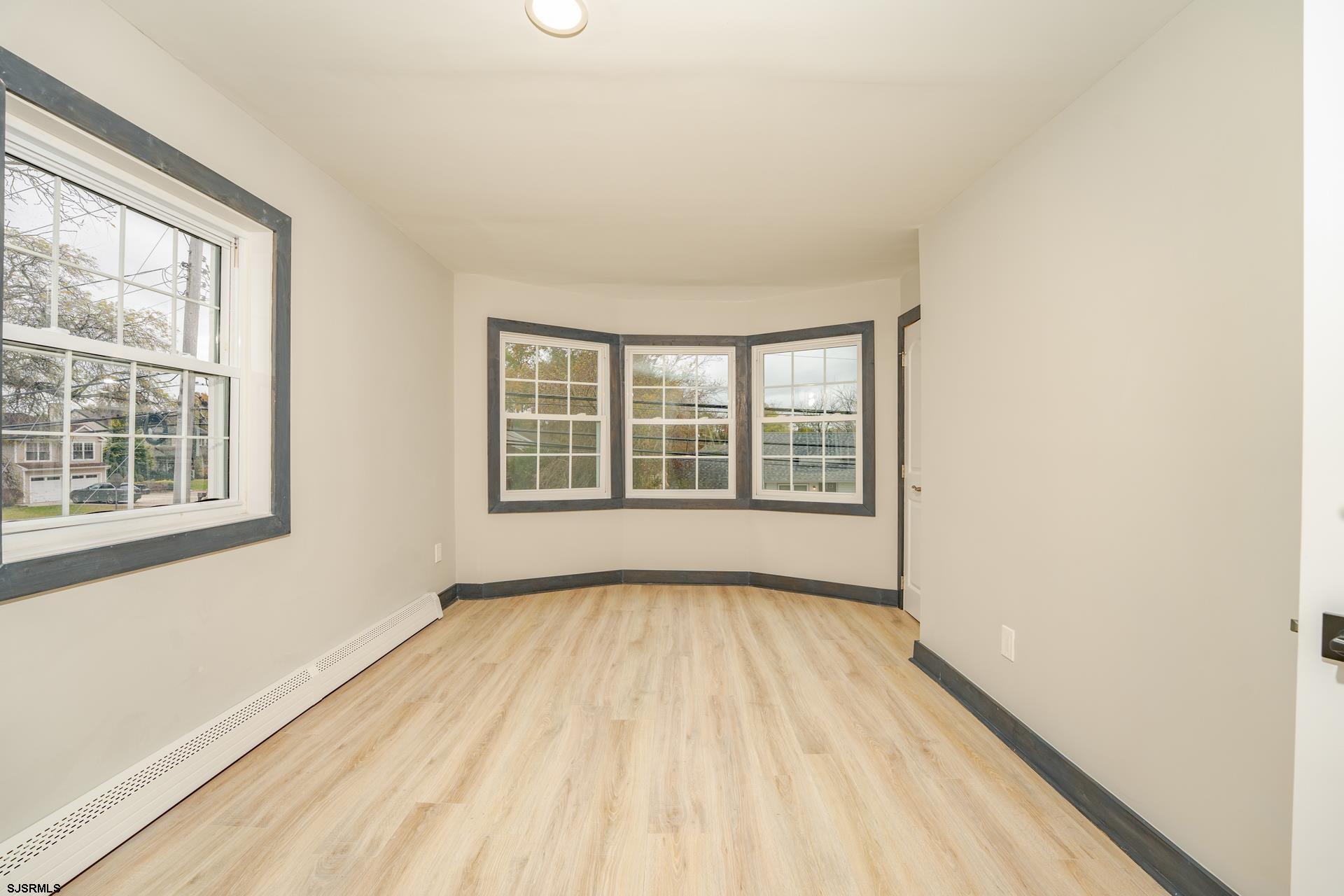 1203 West Mill Road Northfield, NJ 08225 - Photo 19 of 90 an empty room with wooden floor and windows