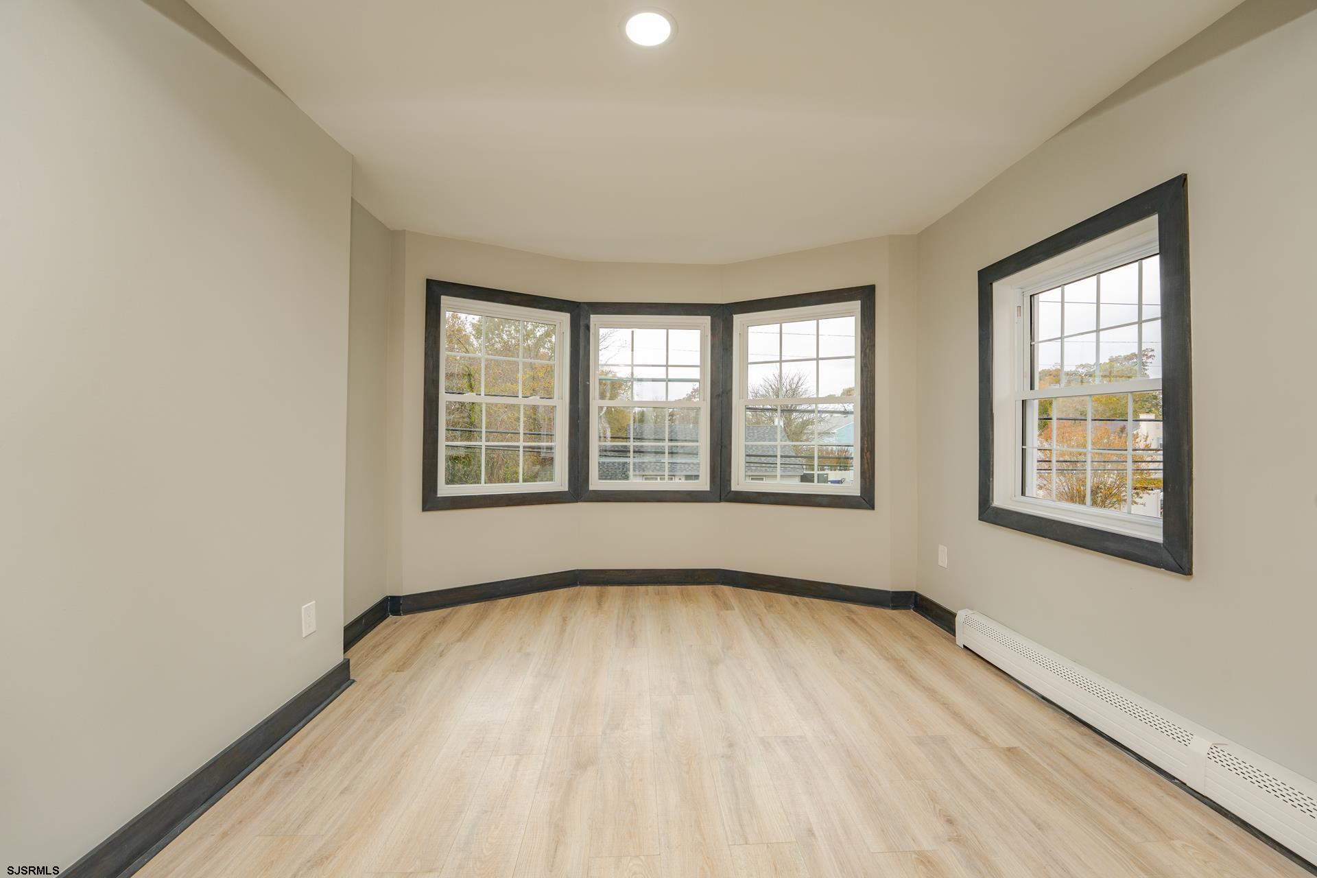 1203 West Mill Road Northfield, NJ 08225 - Photo 23 of 90 a view of an empty room with a window and wooden floor