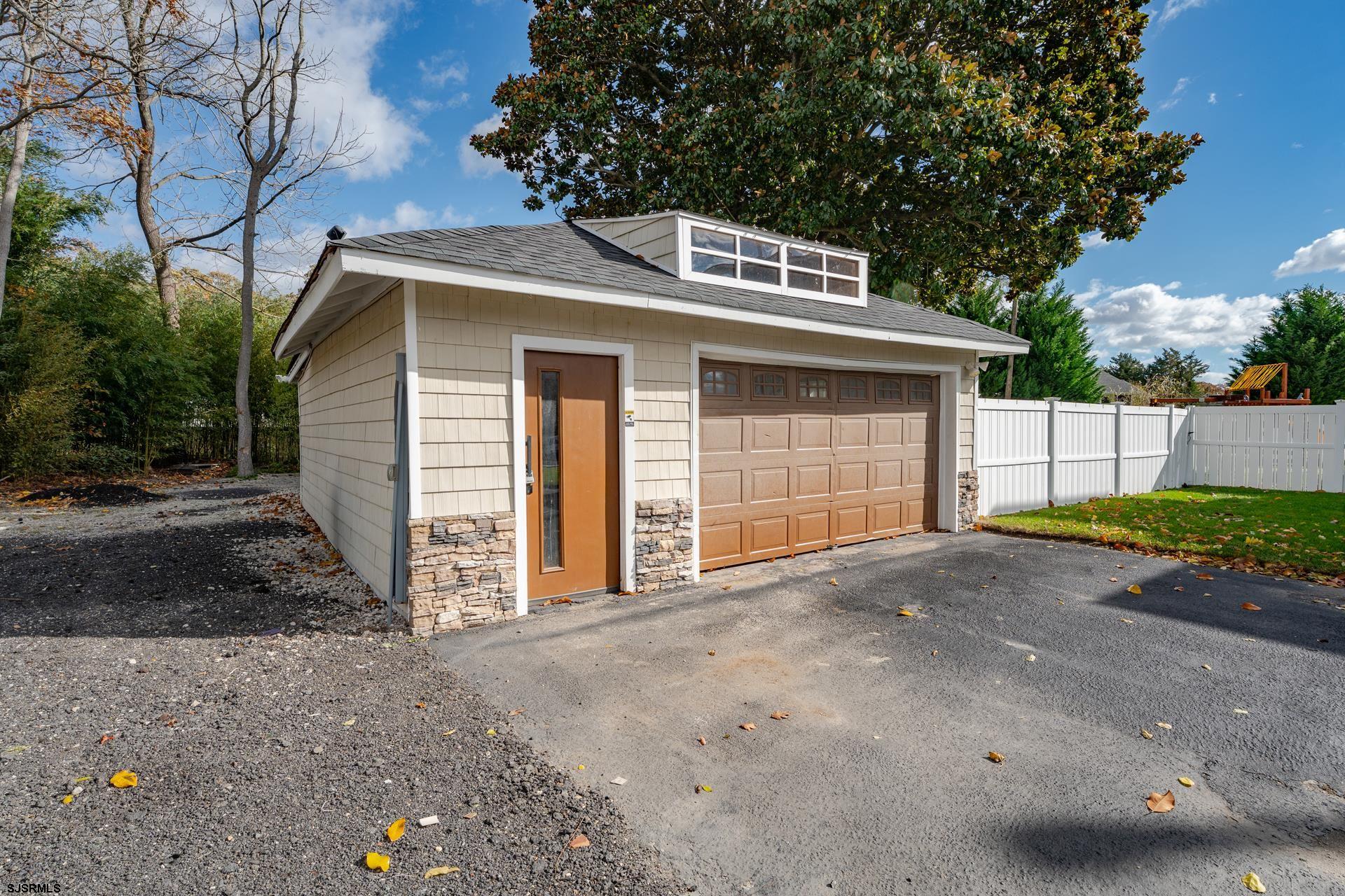 1203 West Mill Road Northfield, NJ 08225 - Photo 50 of 90 a front view of a house with a yard and garage
