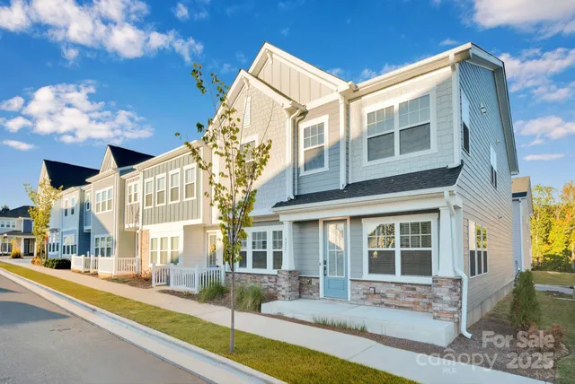 a front view of a building with a garden and plants