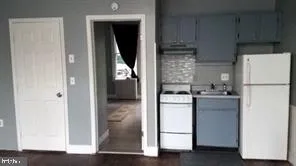 a kitchen with a refrigerator sink and cabinets