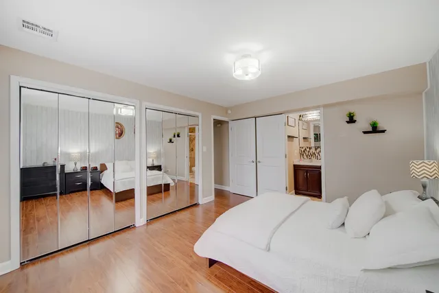 a bedroom with a bed and a view of living room