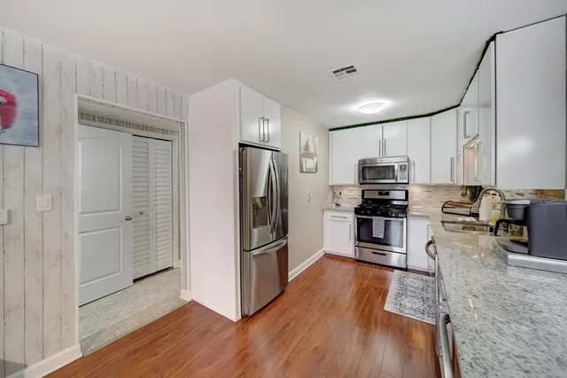 a kitchen with stainless steel appliances a refrigerator and a stove top oven
