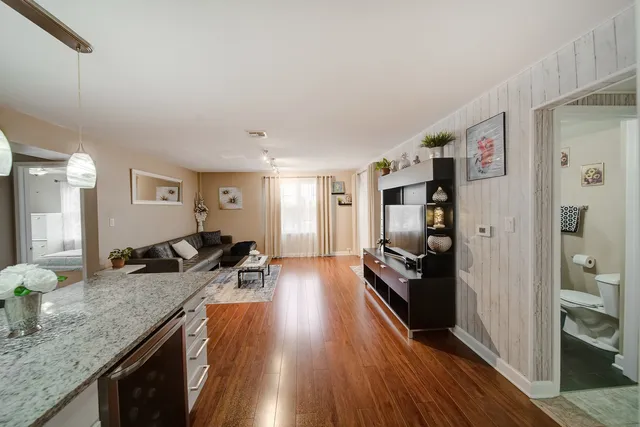 a kitchen with granite countertop a refrigerator stove oven and wooden floor