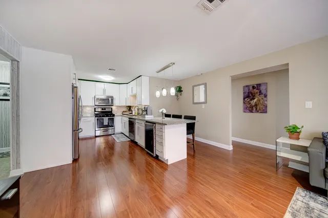 a view of kitchen with wooden floor and electronic appliances