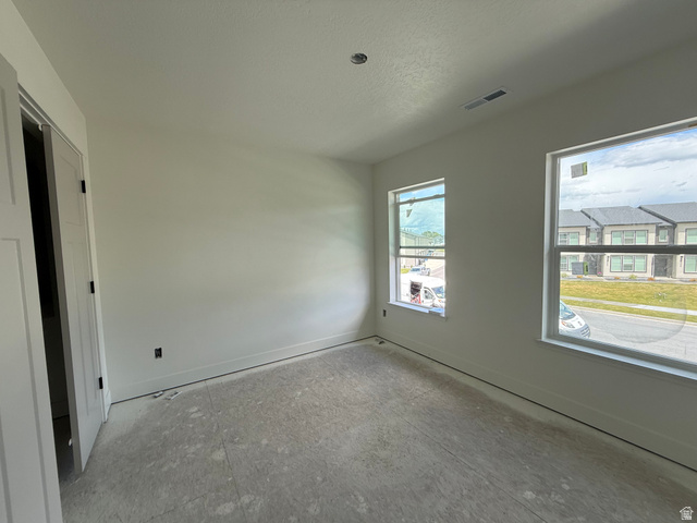 1008 West 3410 South Nibley, UT 84321 - Photo 20 of 26 Bright interior space featuring two large windows, white walls, and a contemporary flat-panel door with black hardware