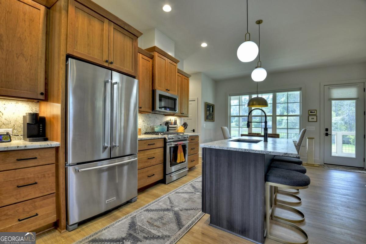 47 Downy Road, Unit 2 Blue Ridge, GA 30513 - Photo 4 of 95 a kitchen with granite countertop stainless steel appliances a refrigerator cabinets and wooden floor
