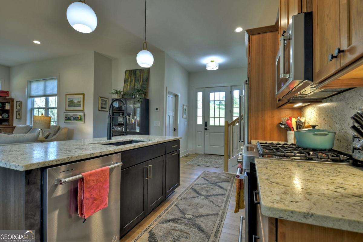 47 Downy Road, Unit 2 Blue Ridge, GA 30513 - Photo 74 of 95 a kitchen with stainless steel appliances granite countertop a stove a sink and a microwave
