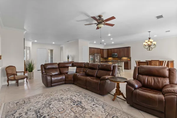 a living room with furniture kitchen view and a chandelier