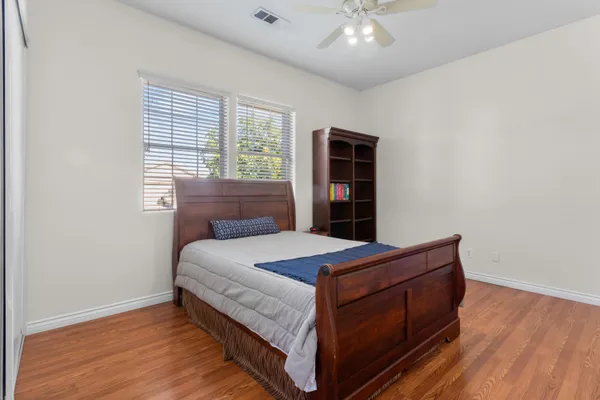 a bedroom with a bed and wooden floor
