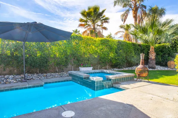 a view of a house with backyard and swimming pool