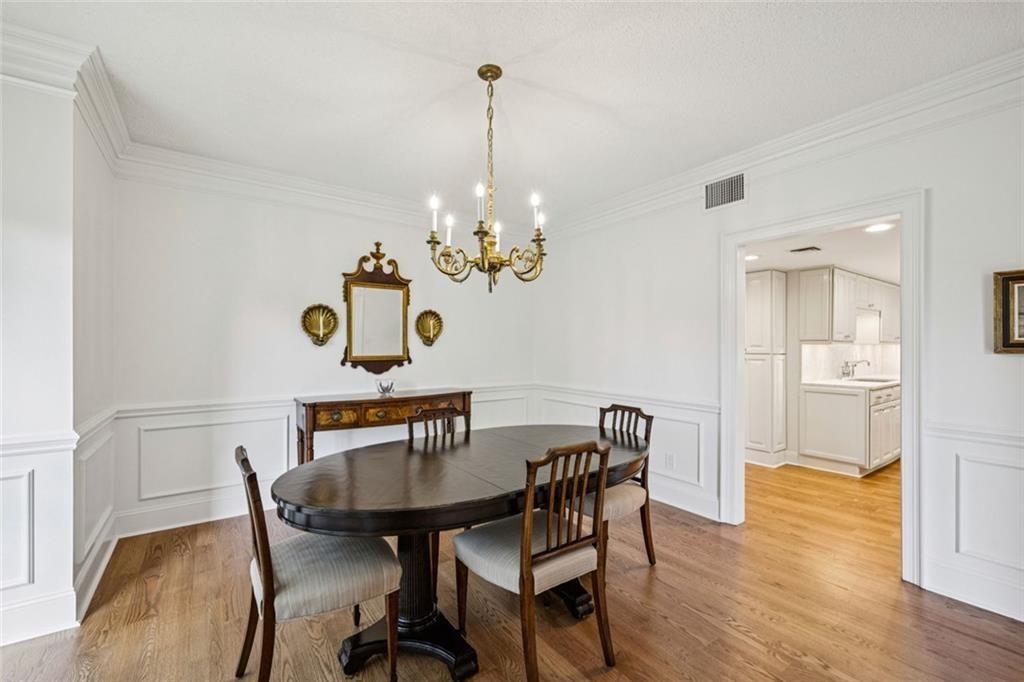 2765 Peachtree Road Northeast, Unit 3 Atlanta, GA 30305 - Photo 10 of 30 a view of a dining room with furniture wooden floor and a chandelier