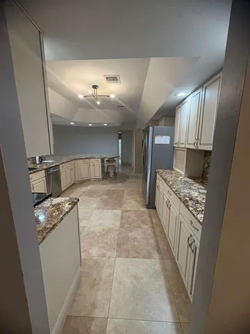 a kitchen with a sink a stove top oven and cabinets