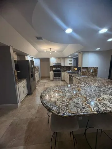 a kitchen with stainless steel appliances granite countertop a sink and a refrigerator