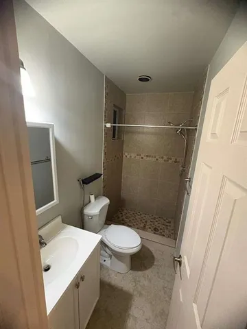 a white toilet sitting next to a bathroom sink and a shower