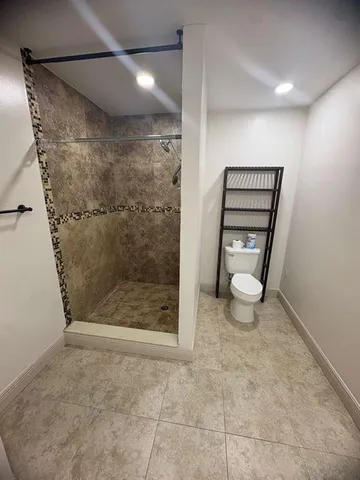 a bathroom with a toilet and a shower