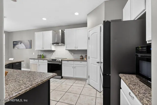 a kitchen with granite countertop white cabinets and a stove