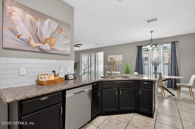 a kitchen with granite countertop kitchen island white cabinets and stainless steel appliances