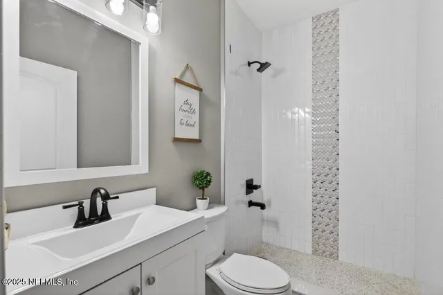 a bathroom with a sink toilet vanity and shower