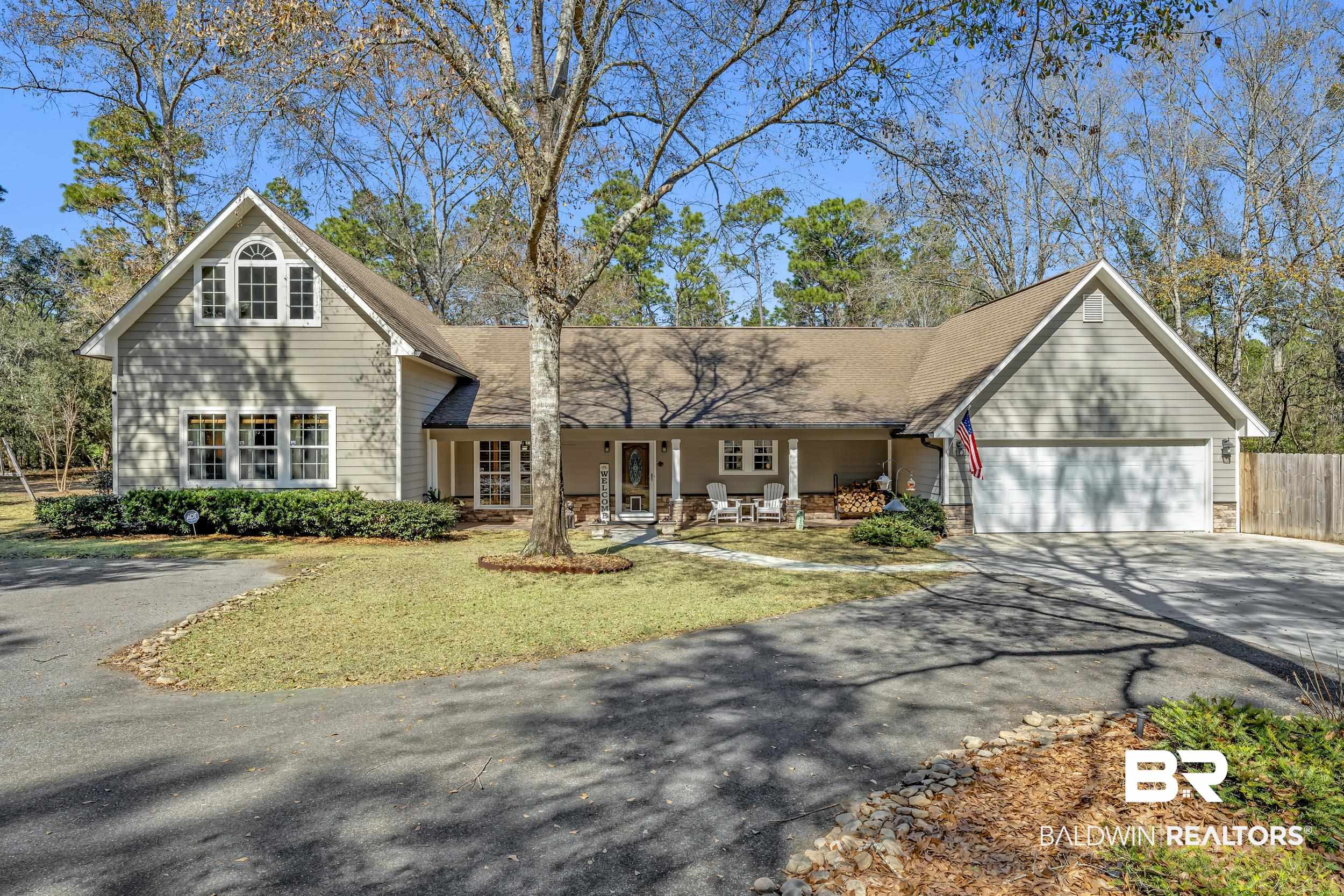 22929 Highway 98 Foley, AL 36535 - Photo 2 of 54 View of front facade with asphalt driveway, a porch, a garage, a shingled roof, and stone siding