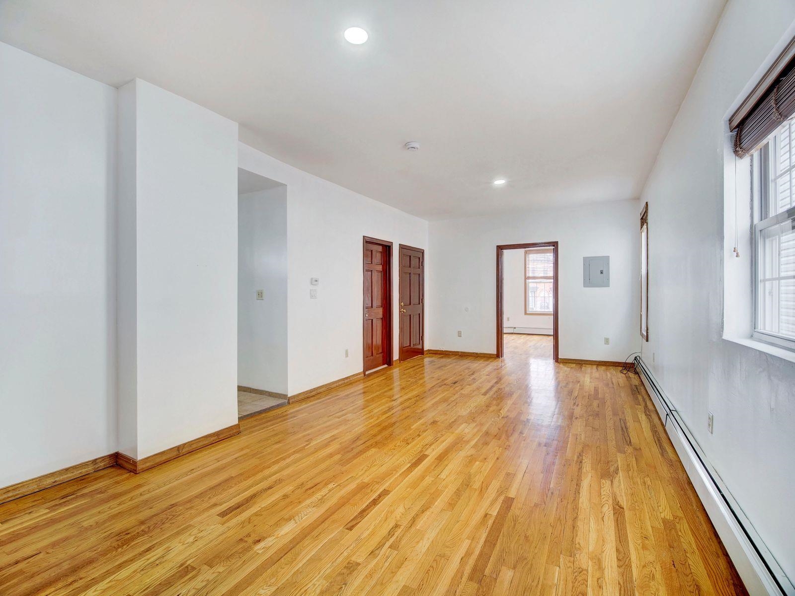 921 Paterson Plank Road, Unit 2 North Bergen, NJ 07047 - Photo 10 of 15 a view of an empty room with wooden floor and a window
