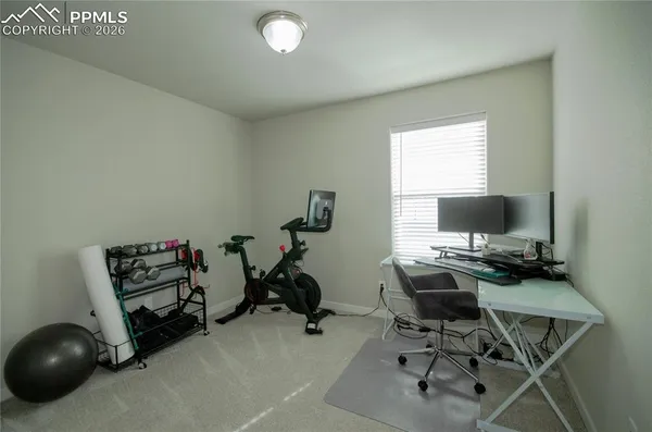 a view of a workspace with furniture and a window