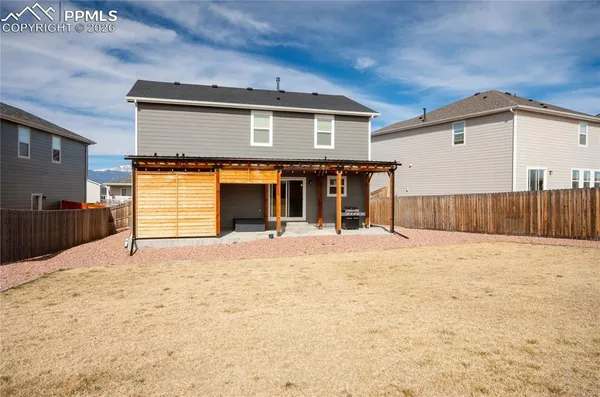 a view of backyard with wooden fence