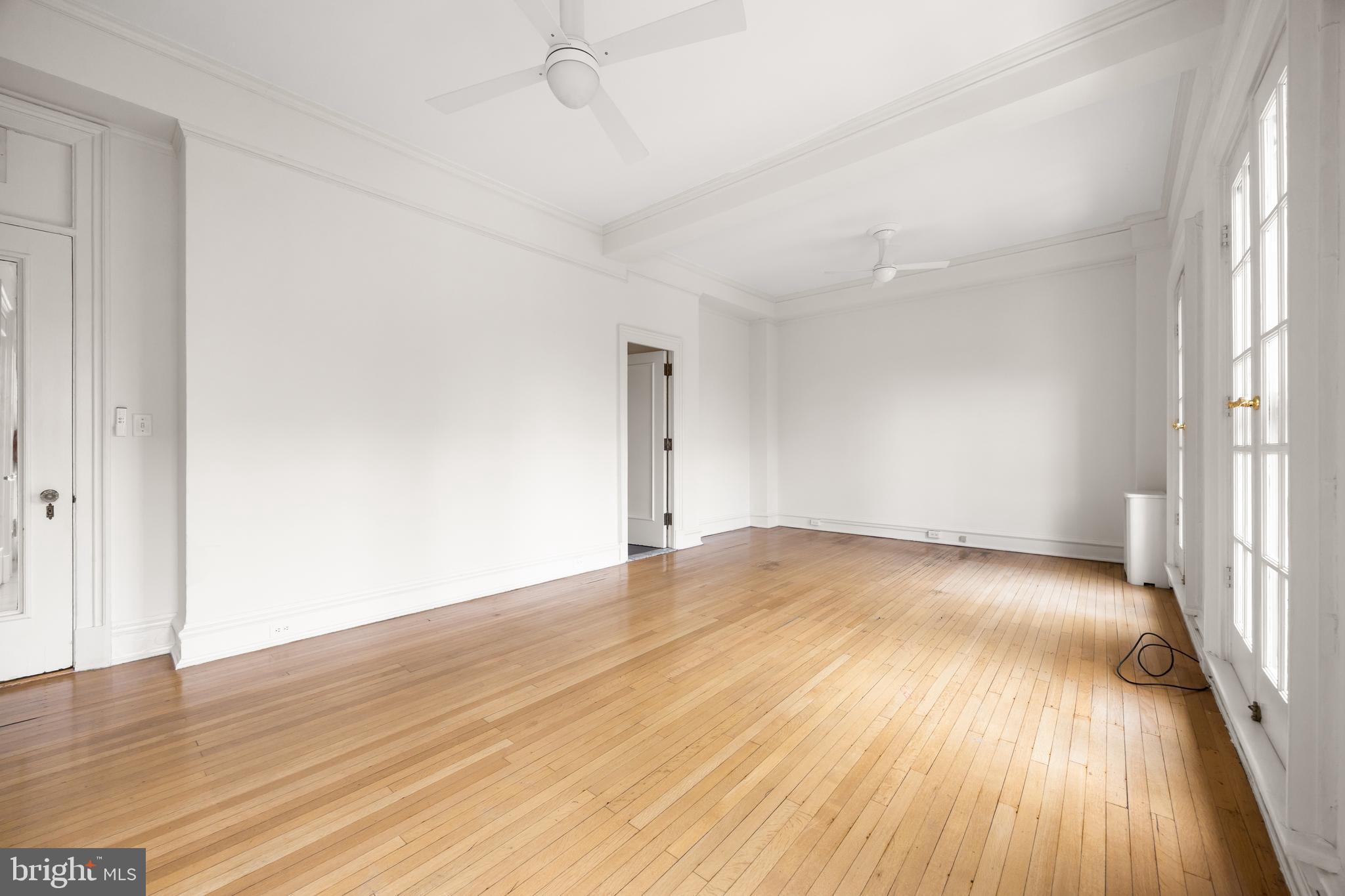 700 Washington Place, Unit 4B Baltimore, MD 21201 - Photo 24 of 67 an empty room with wooden floor and windows