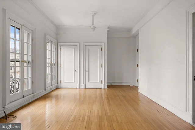 a view of an empty room with a window and wooden floor