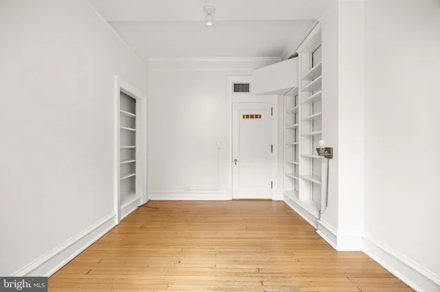 a view of an empty room with window and cabinet