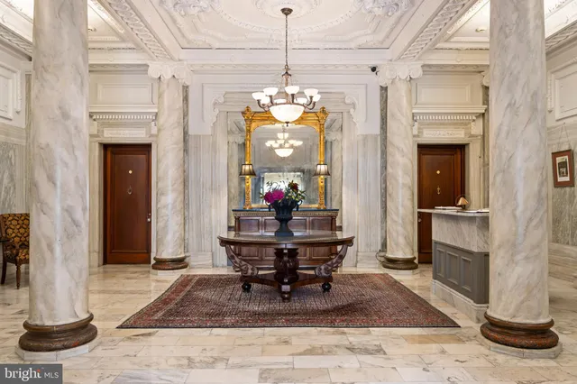 a view of a hallway with wooden floor and a chandelier