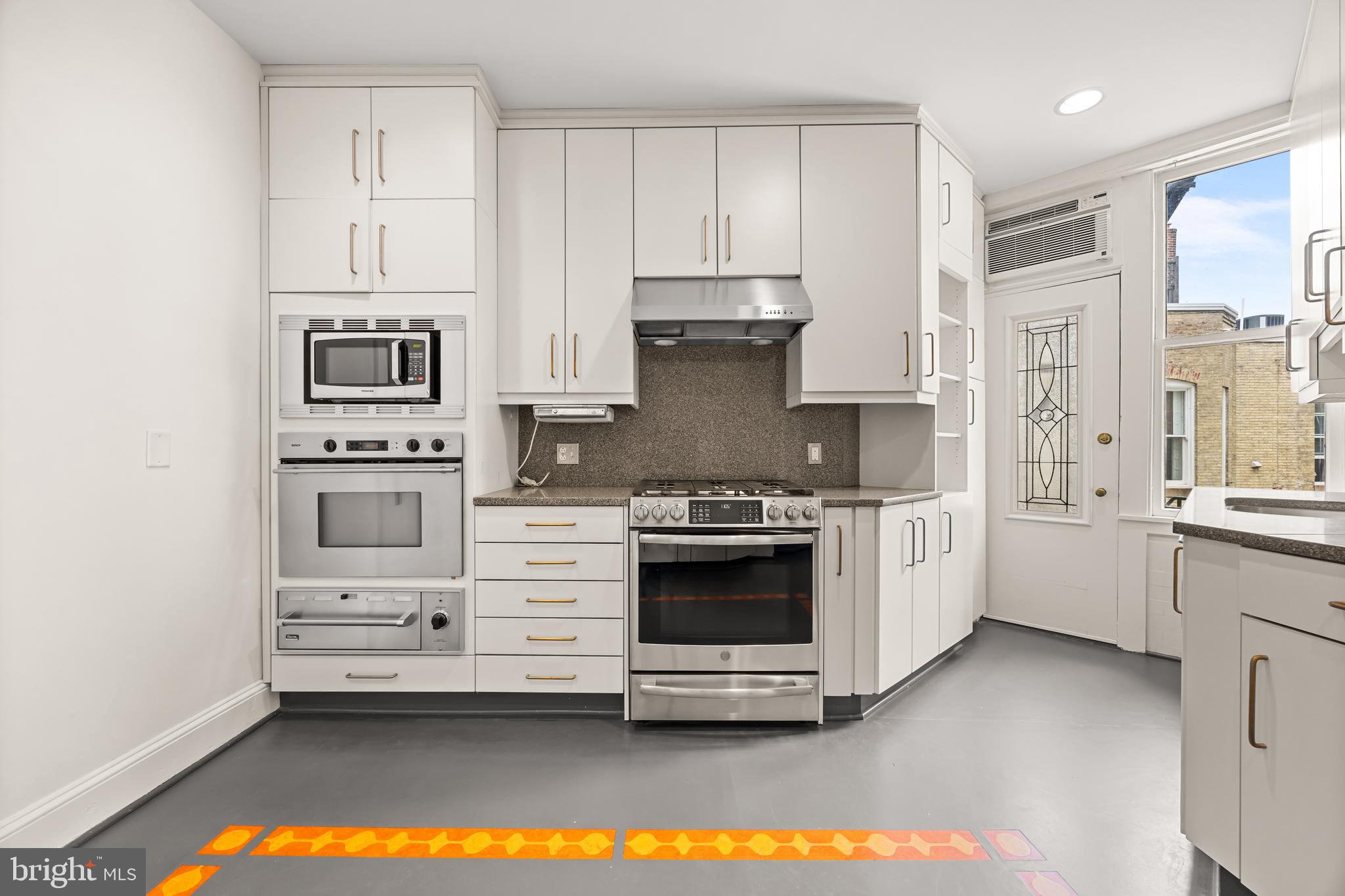 700 Washington Place, Unit 4B Baltimore, MD 21201 - Photo 54 of 67 a kitchen with stainless steel appliances a stove a sink and a microwave