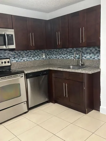 a kitchen with a sink and a stove top oven