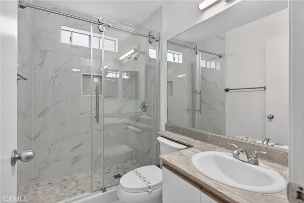 a bathroom with a sink a toilet and shower
