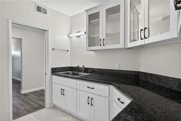 a kitchen with stainless steel appliances granite countertop white cabinets and sink
