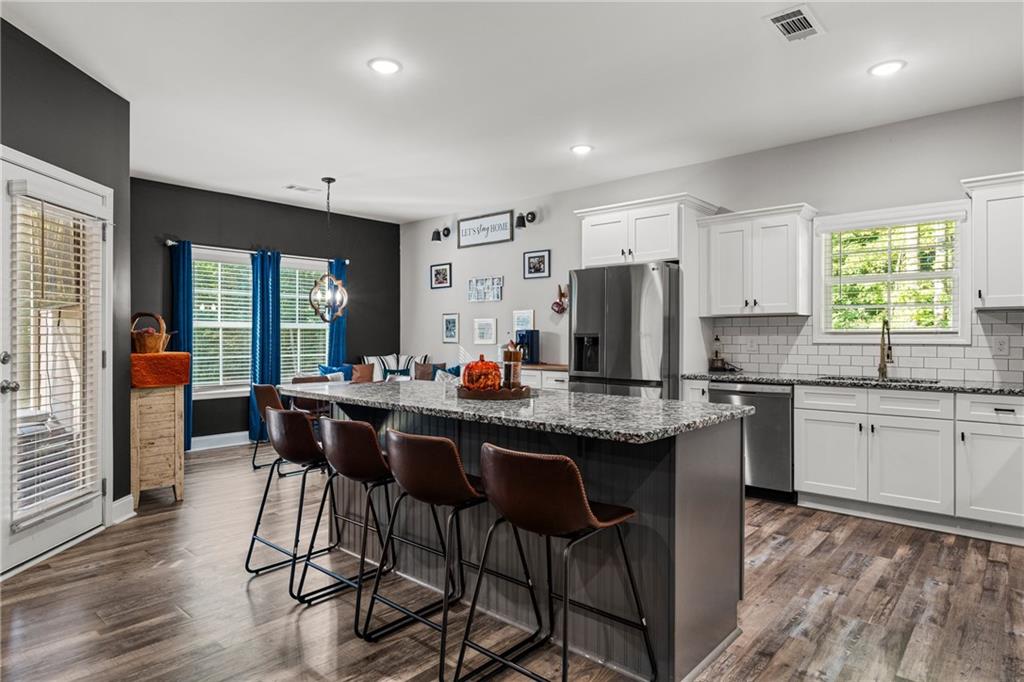 3696 Lee Road Salem, AL 36874 - Photo 11 of 36 Open-concept kitchen and living area featuring wood-finish flooring, recessed lighting, and a kitchen island with stone countertops