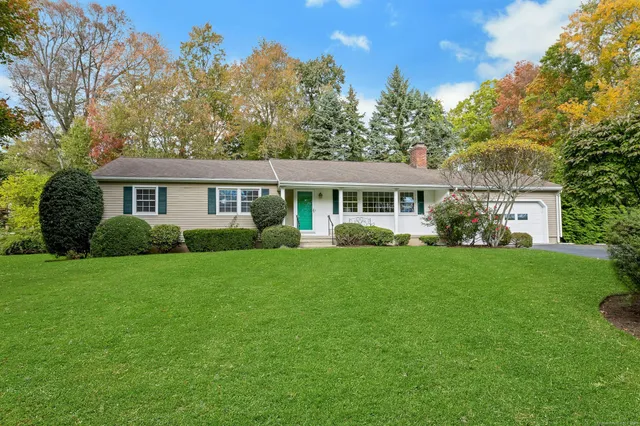 a view of a house with a yard and potted plants
