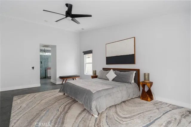 a bedroom with a bed and a ceiling fan